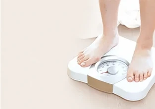 체중계 위에 올라선 발 — 무리한 다이어트로 인한 입냄새