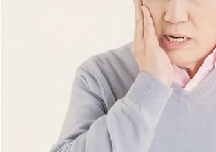 볼을 감싸 쥔 남성 — 구내염으로 인한 입냄새